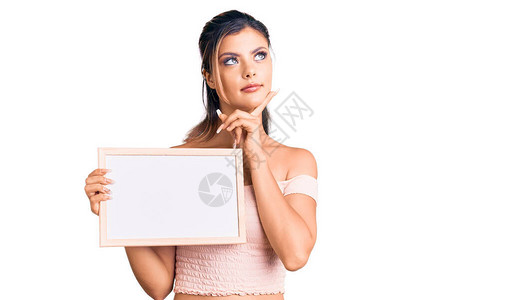 年轻漂亮的女人拿着空白的黑板严肃的脸图片