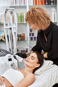 在温泉水疗养所用专业机器做女脸部手术的美容师有激光面部神图片