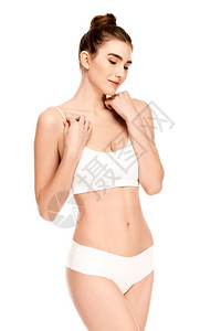 顶和内裤的梦想中的年轻模特儿站在白背景图片