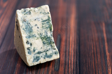 深色木质背景上的大块蓝纹奶酪背景图片
