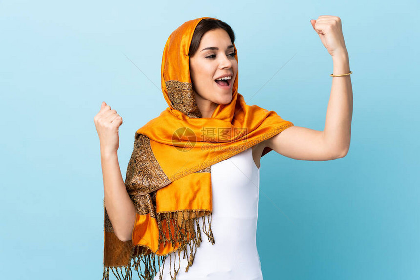 穿着传统服装的摩洛哥年轻女子在蓝背景下被孤立图片