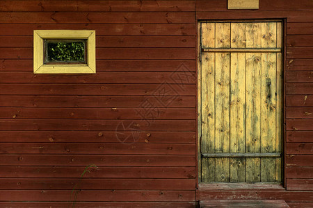 一扇黄色的木门和墙上的一扇小窗户图片