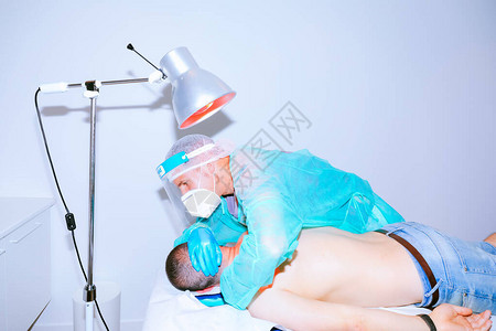 身戴面罩面具和乳胶手套的理疗师图片
