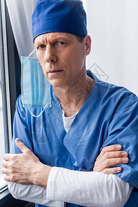蓝色洗蓝帽和医疗面具的成熟医生与图片