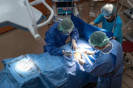 在手术室工作的一组外科医生医疗队进行手术图片
