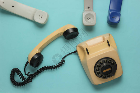 电话办公室概念旧旋转式电话许多蓝色背景的听筒顶视图片