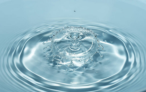干净清新的水滴从清澈透明的蓝色水的高度落下图片