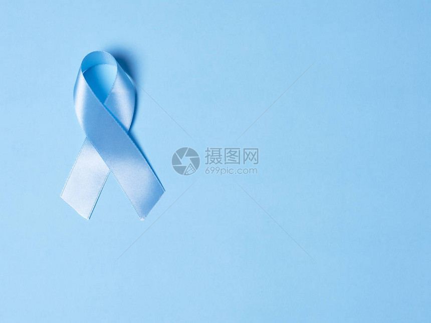 蓝色缎带象征着亮蓝色背景上的前列腺癌意识医学和保健的概图片