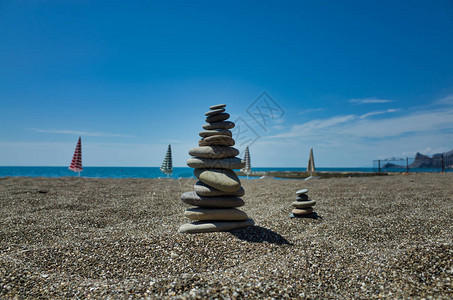 卵石滩上的石头金字塔象征着稳定禅宗和谐平衡浅景深背图片