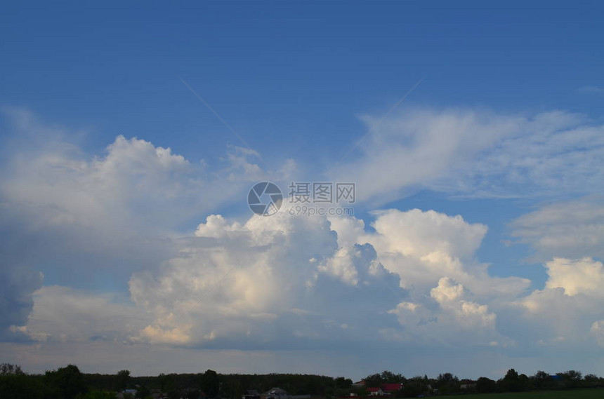 照片描绘了蓝色的夏日天空云层覆图片