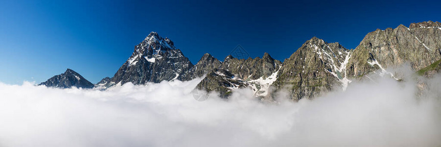 山脊和阿尔卑斯山峰在云层上浮现图片