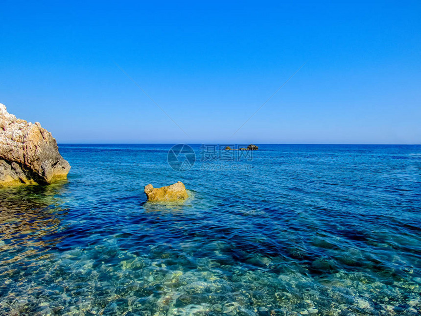 塞浦路斯普罗塔拉斯岛海滨水域的石块上方有蓝色图片