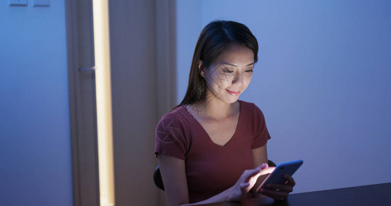 妇女晚上在家使用手机的情况妇女在夜间图片