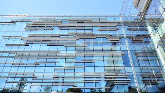 现代办公楼在建筑物的窗户中反射位于市中图片