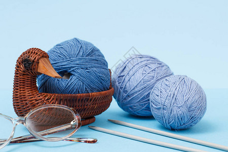 编织线球金属编织针头眼镜和蓝底篮子图片