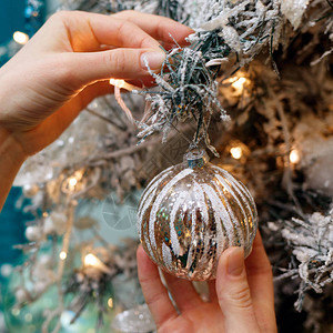 用银球装饰圣诞树的女手图片