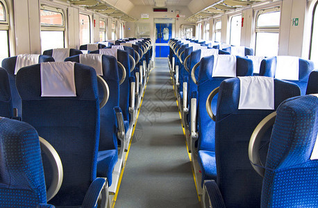 现代城际特快列车的内部在铁路运输中排成一排的宽大舒适座椅的后视图空荡的沙龙背景图片