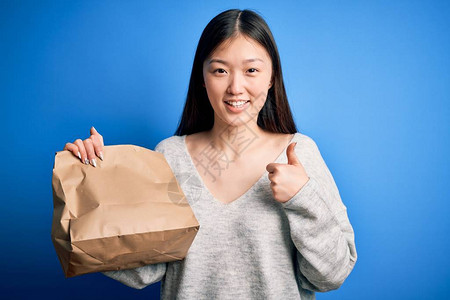 年轻的亚洲女拿着送外卖的纸袋图片