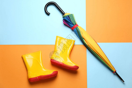 彩色背景上的时尚雨伞和橡胶靴图片