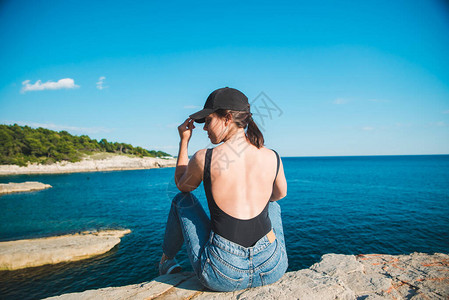坐在悬崖边的年轻美女看着暑假图片