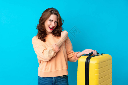 带着手提箱的单身蓝背景旅行女旅客庆祝胜利背景图片