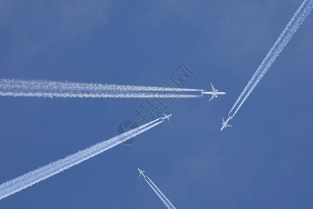 在蓝天中穿越化学痕迹的客机背景图片