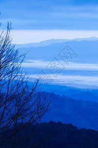 梦幻般的蓝色云彩和蓝色山脉上的日出天空图片