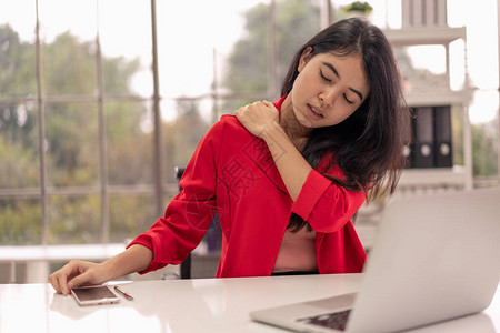 商业妇女因在办公室工作而得颈部和肩部疼痛图片