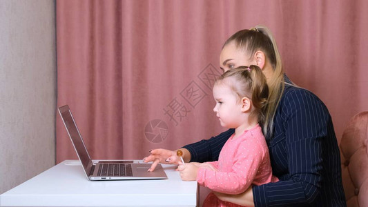 母亲和儿子在家上课看笔记本电脑图片