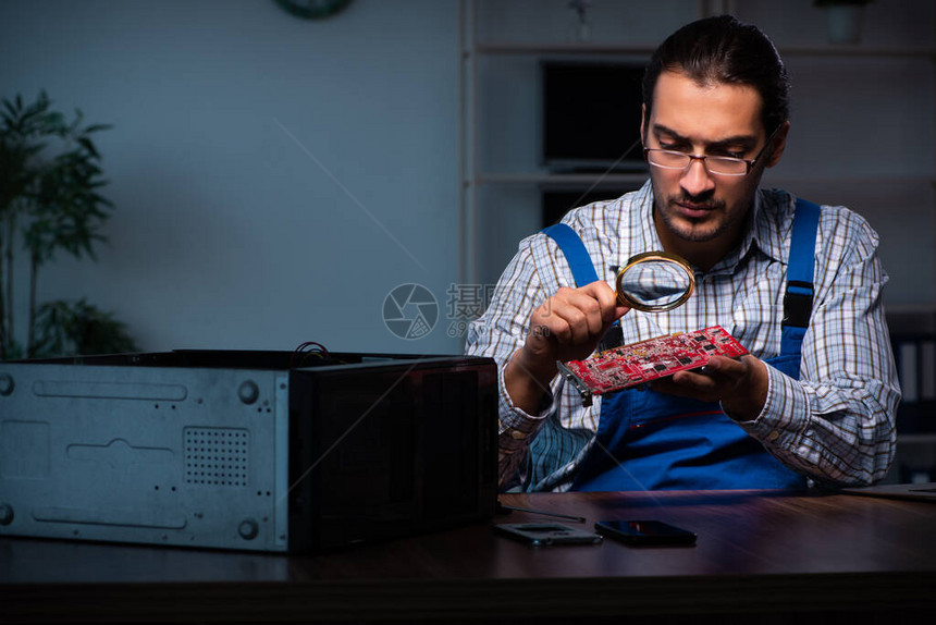 夜间在车间修理计算机的年轻图片