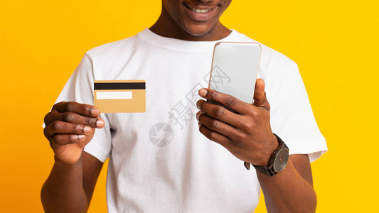 使用手机和信用卡黄色背景全景图轻松进行在线支付图片