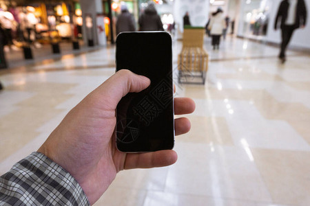 男手持智能手机在购物中心用手机图片