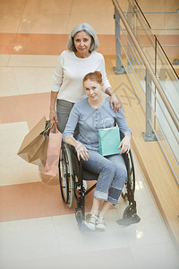 在商场与年长母亲购物的轮椅残疾妇图片