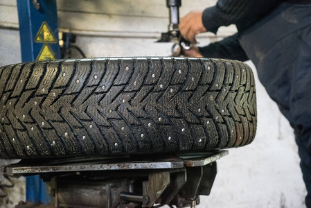 汽车修理工更换车轮上的轮胎师傅在工作车轮背景图片