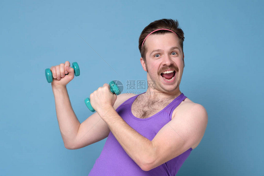 有趣的人锻炼和做运动训练幽默的健美运动员使用小哑铃进行健美运动图片