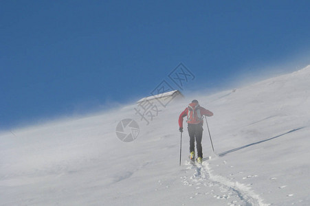 滑雪登山者在山间的风暴中攀爬图片