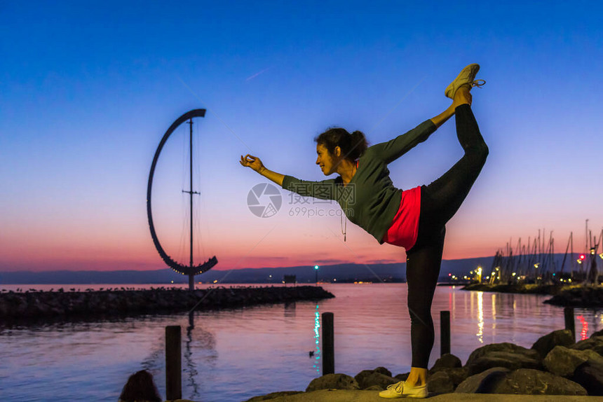 瑞士洛桑日落时分站在湖前码头上的女人图片