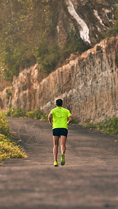在郊区山路上的下坡上坡慢跑的人图片