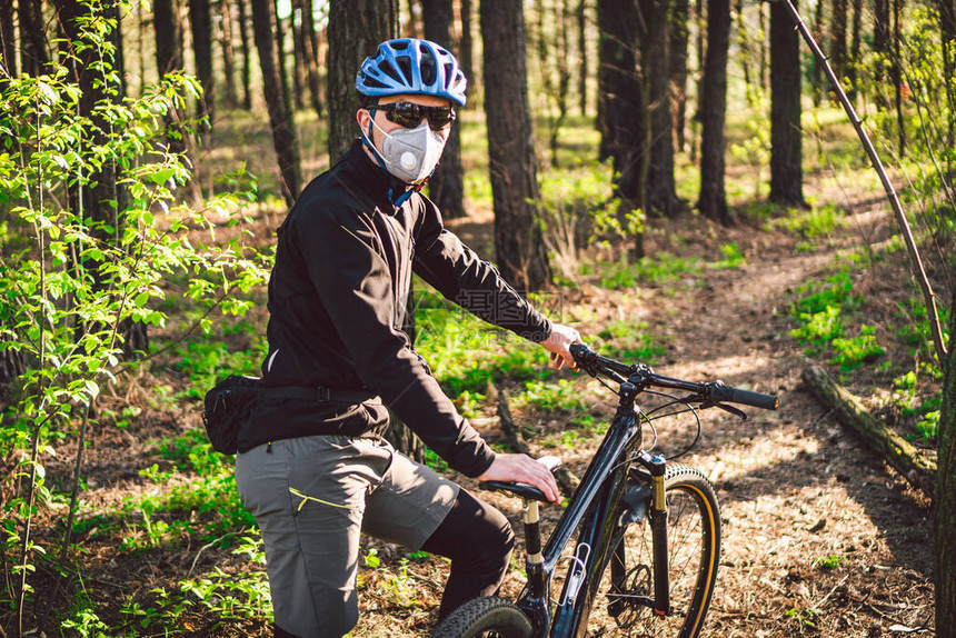 山地自行车骑单车骑行者骑自行车的人戴着带有重型防护过滤器的呼吸器面罩安全呼吸面罩污染概念在森林里图片