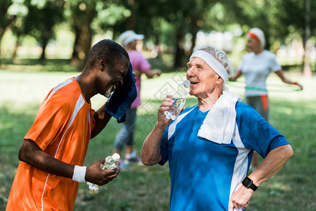 体育多元文化退休男子在老年妇女附近拿着水瓶图片
