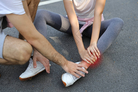 帮助身穿运动西装伤脚踝的女慢跑男青年男子图片