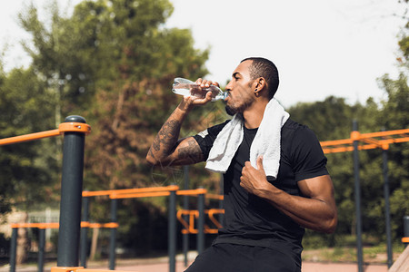早上锻炼运动场锻炼后喝水的运动型男子图片