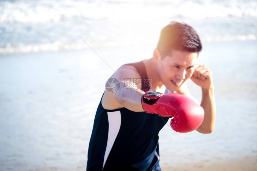 运动男子拳击手训练和冲孔红手套图片