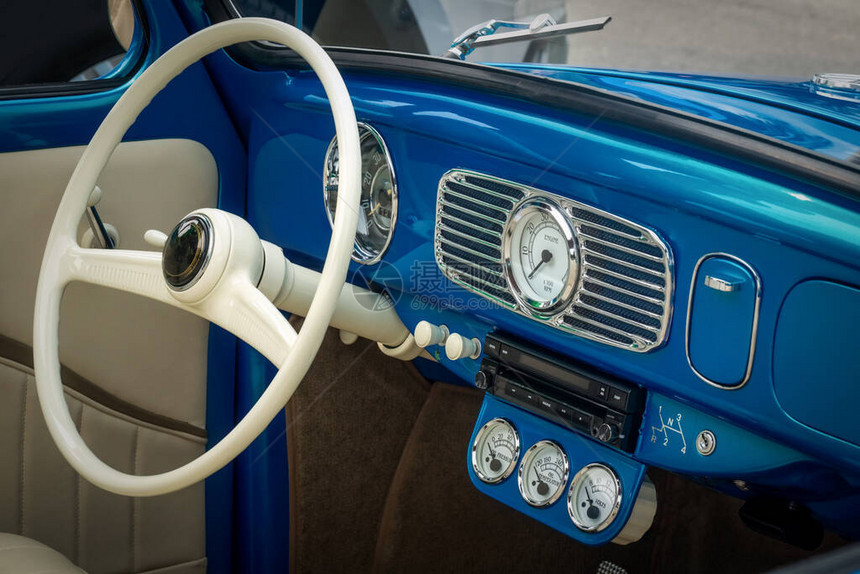 蓝色的旧定时器车的内部分有方向盘速度计油温度图片
