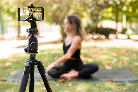 健身运动和视频博客概念在户外记录瑜伽课的三脚手机上移图片