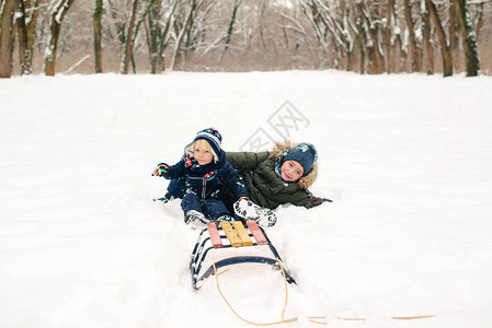 快乐的兄弟躺在户外的雪地上孩子们在冬季公园一起玩乐快乐健康的童年冬季图片