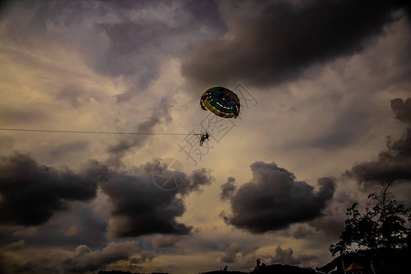 泰国普吉岛卡伦海滩上空的滑翔伞高飘扬图片