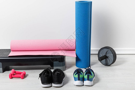 家中地板上的踏步平台健身垫和运动服背景图片