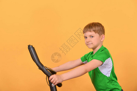 男孩乘坐固定的自行车参加运动并接图片