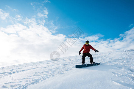 穿戴头盔的运动滑雪机在斜坡上骑行用图片